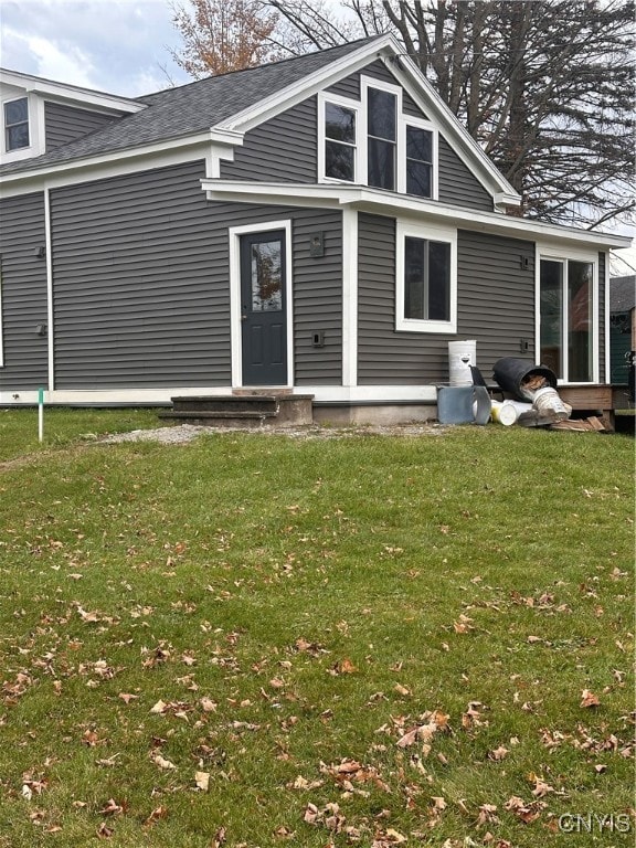 rear view of house featuring a yard