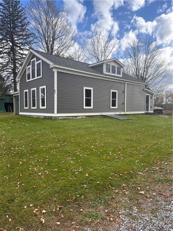 rear view of property with a patio and a lawn