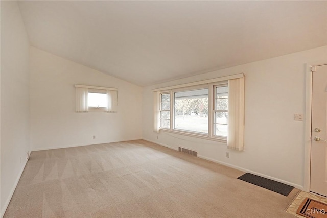 spare room with light carpet and lofted ceiling