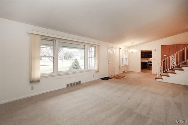 interior space with light carpet, a chandelier, and vaulted ceiling