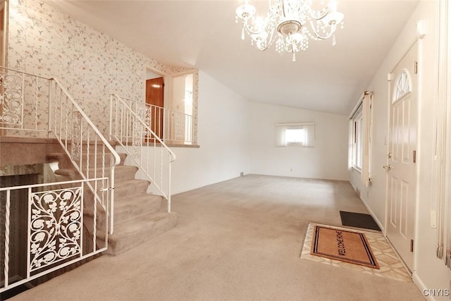 unfurnished living room with carpet, lofted ceiling, and a notable chandelier