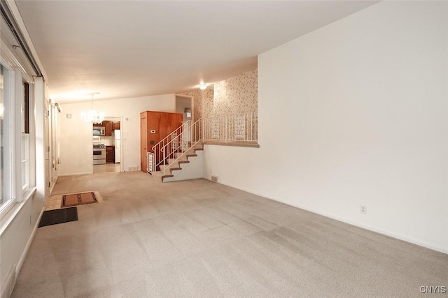 carpeted empty room with a chandelier