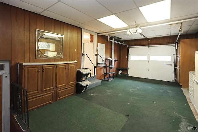 garage with a garage door opener and wooden walls