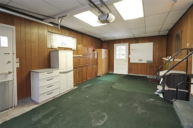 misc room featuring a paneled ceiling and wooden walls