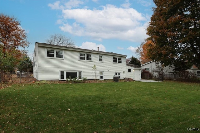 rear view of house with a yard and central AC unit