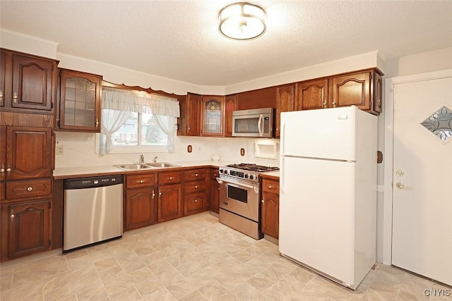 kitchen featuring a textured ceiling, crown molding, sink, and stainless steel appliances