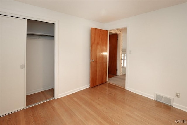 unfurnished bedroom with hardwood / wood-style floors and a closet