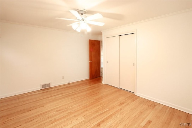 unfurnished bedroom with light wood-type flooring, a closet, ceiling fan, and ornamental molding