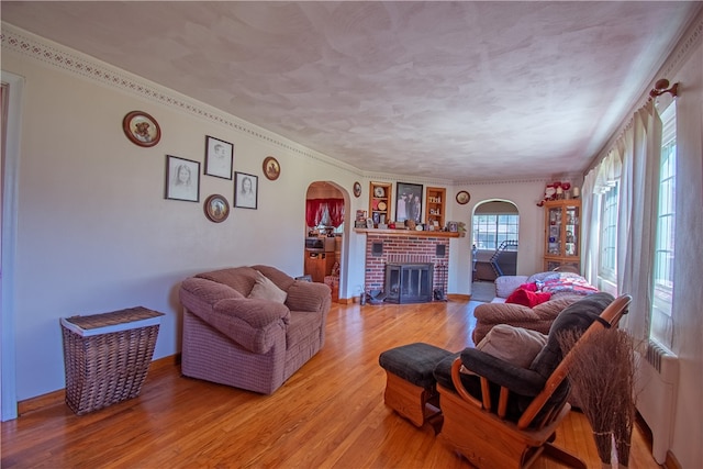 living room featuring crown molding, hardwood / wood-style floors, and a fireplace