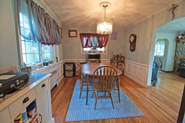 dining space with crown molding, a healthy amount of sunlight, a chandelier, and light wood-type flooring