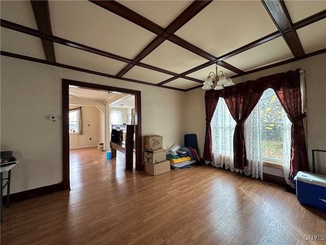 living room with a wealth of natural light, coffered ceiling, wood-type flooring, and a chandelier