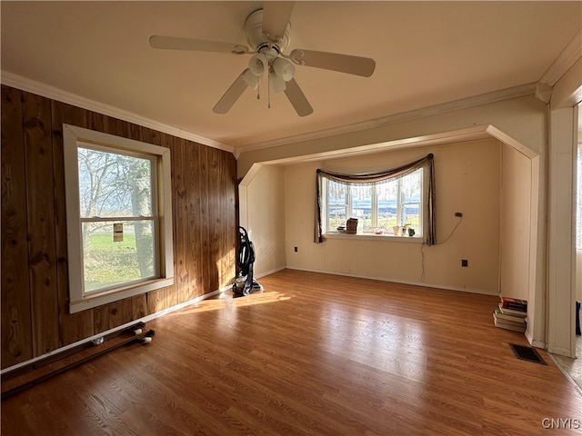 interior space featuring a wealth of natural light, ornamental molding, light hardwood / wood-style flooring, and ceiling fan