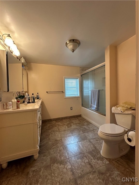 full bathroom with vanity, bath / shower combo with glass door, and toilet