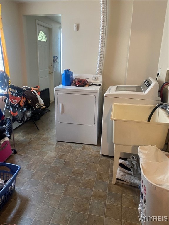 clothes washing area featuring sink and washer and dryer