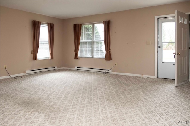 empty room featuring baseboard heating and light colored carpet