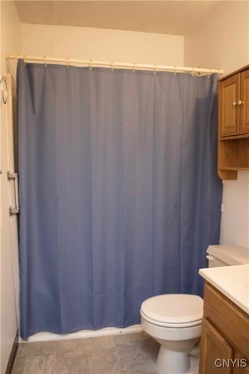 bathroom with toilet, a shower with curtain, vanity, and tile patterned flooring