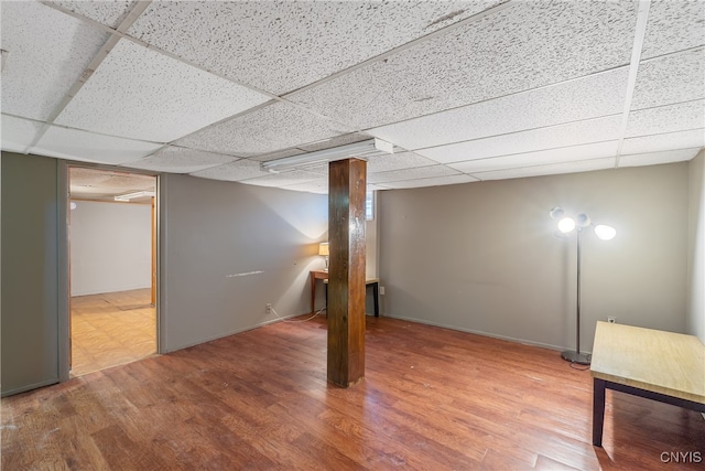 basement with a drop ceiling and hardwood / wood-style floors