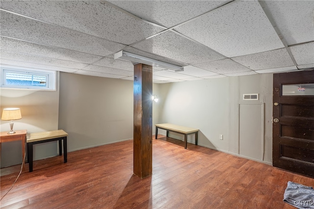 basement with a drop ceiling and wood-type flooring