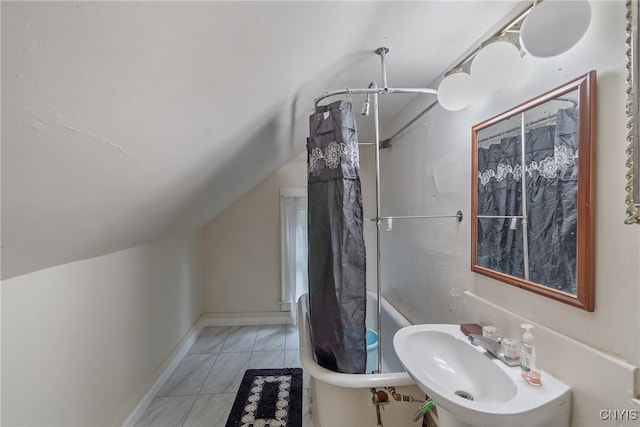 bathroom featuring sink, tile patterned floors, vaulted ceiling, and a shower with shower curtain