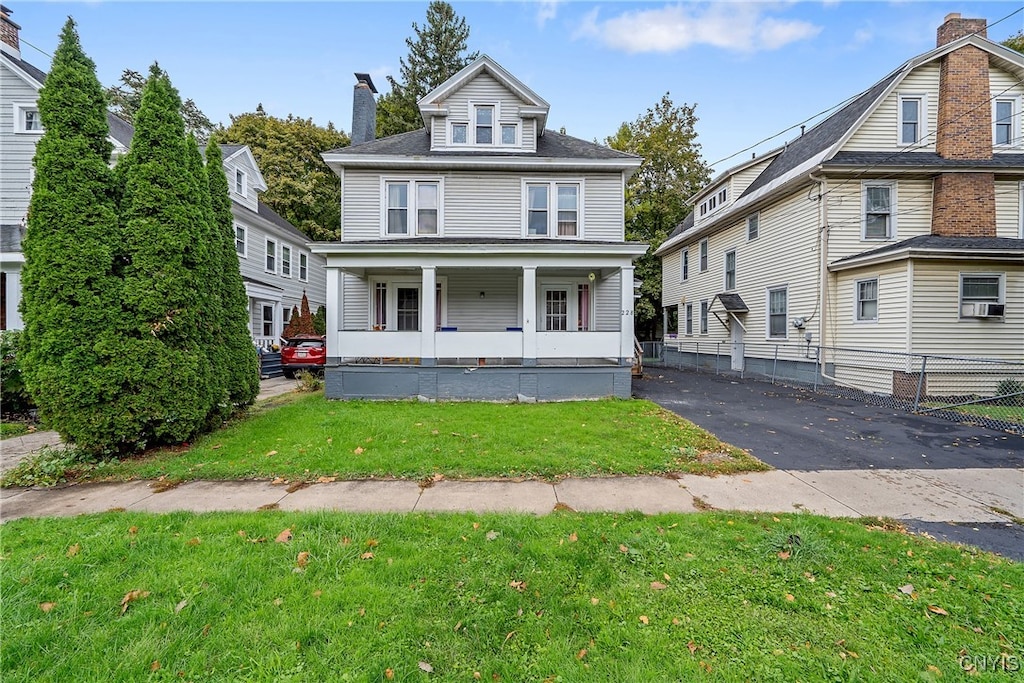 view of front of property with covered porch and a front lawn