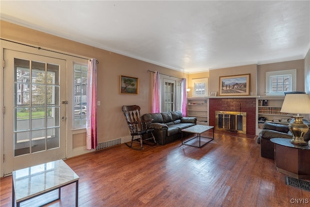 living room featuring ornamental molding, a fireplace, and wood-type flooring