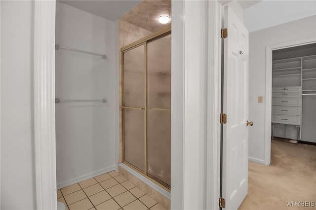 bathroom with a shower with door and tile patterned flooring