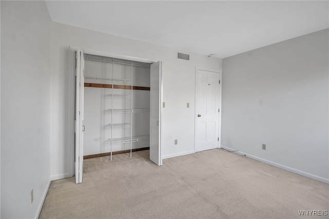 unfurnished bedroom featuring a closet and light carpet