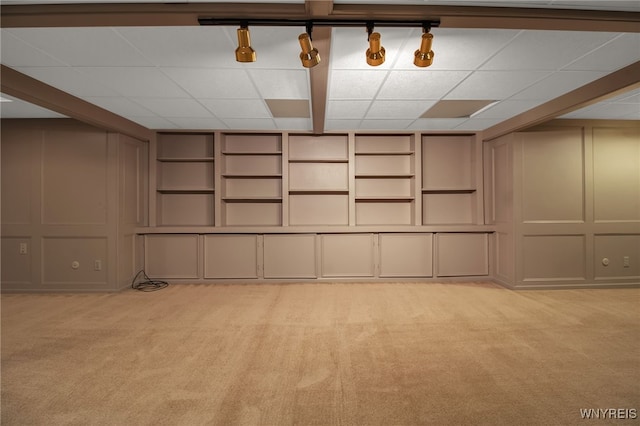 basement with a drop ceiling and light colored carpet