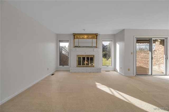 unfurnished living room featuring light carpet and a brick fireplace