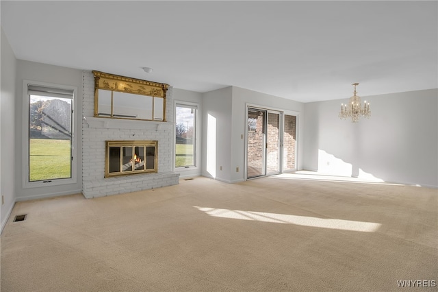 unfurnished living room featuring light carpet, a fireplace, and a healthy amount of sunlight