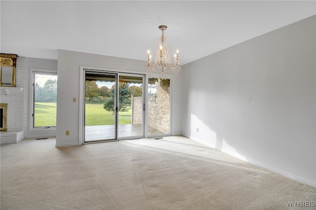 interior space featuring a chandelier, a fireplace, and light colored carpet