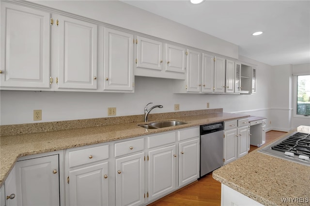 kitchen featuring light hardwood / wood-style flooring, stainless steel appliances, sink, light stone countertops, and white cabinets