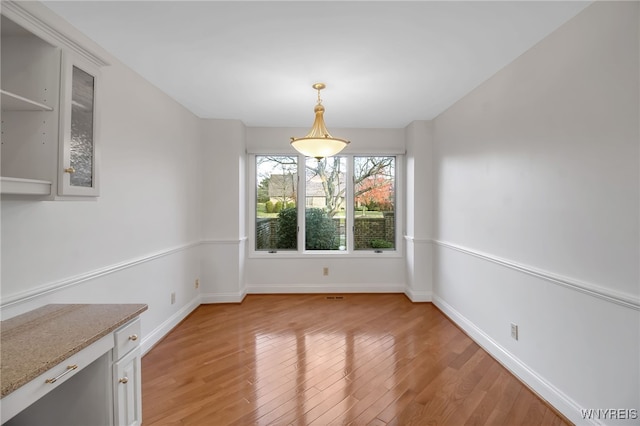 unfurnished dining area featuring light wood-type flooring