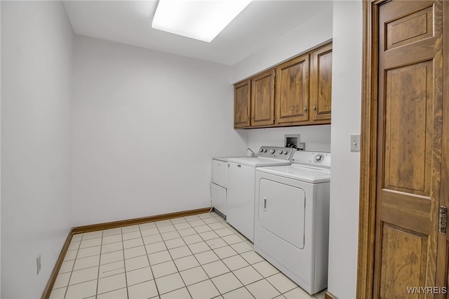 laundry area featuring cabinets, separate washer and dryer, and light tile patterned floors