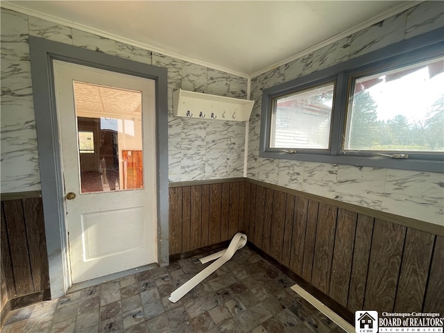 interior space featuring ornamental molding and wooden walls