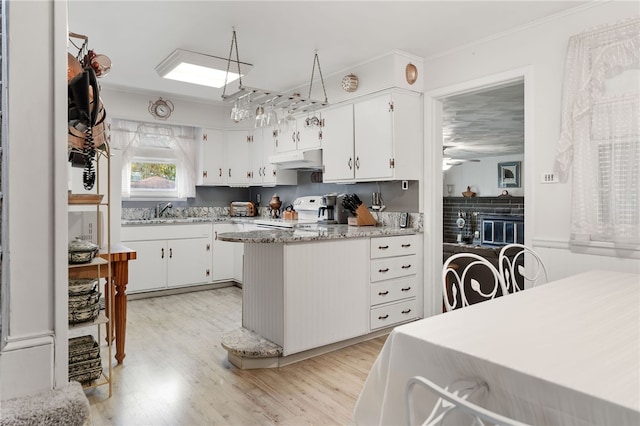 kitchen with ceiling fan, light wood-type flooring, white cabinetry, and range