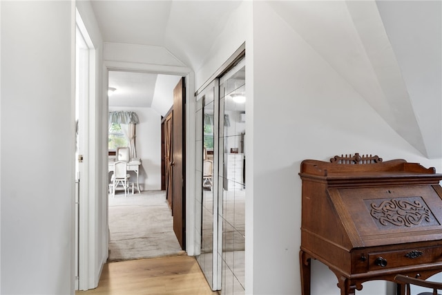 corridor with vaulted ceiling and light hardwood / wood-style flooring