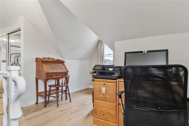 home office with light hardwood / wood-style floors and vaulted ceiling