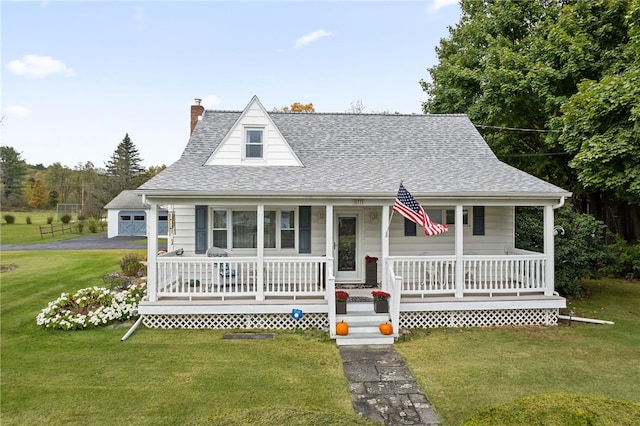 view of front of home featuring an outbuilding, a porch, a garage, and a front lawn