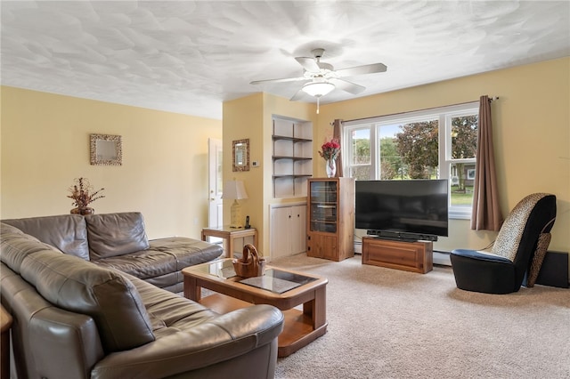 carpeted living room featuring ceiling fan and a baseboard heating unit