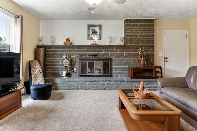 carpeted living room featuring ceiling fan and a brick fireplace