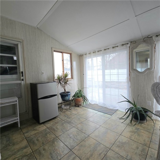 unfurnished sunroom featuring vaulted ceiling