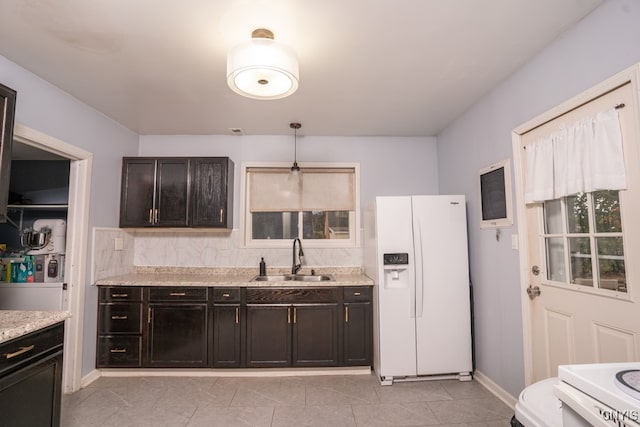 kitchen with white appliances, light stone countertops, sink, pendant lighting, and light tile patterned floors