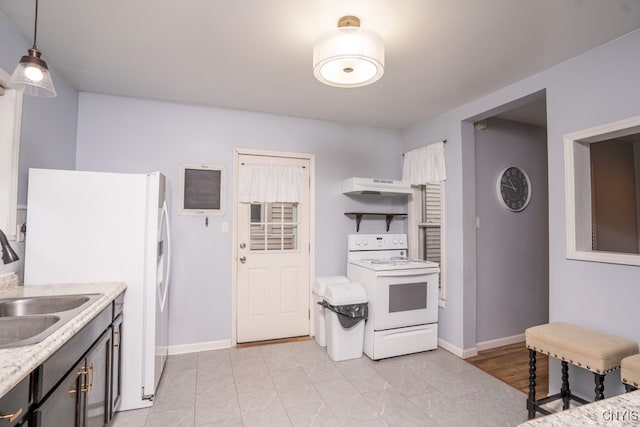 kitchen with exhaust hood, sink, decorative light fixtures, light stone counters, and white appliances