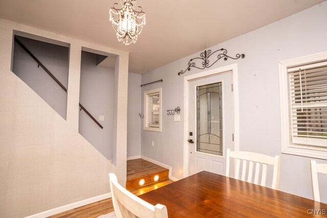 unfurnished dining area with light hardwood / wood-style flooring and a notable chandelier