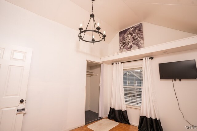 interior space with high vaulted ceiling, a chandelier, and wood-type flooring