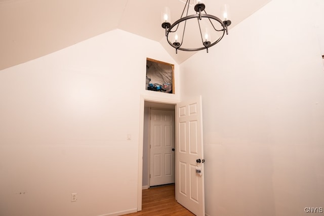 interior space with vaulted ceiling, light wood-type flooring, and an inviting chandelier