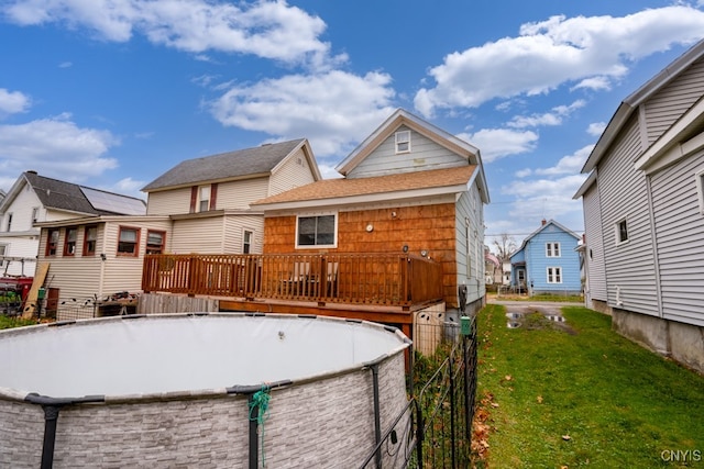 rear view of house featuring a yard and a wooden deck