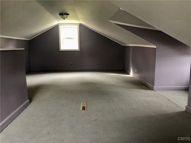 additional living space featuring lofted ceiling and light colored carpet