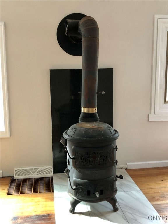 details featuring a wood stove and hardwood / wood-style floors